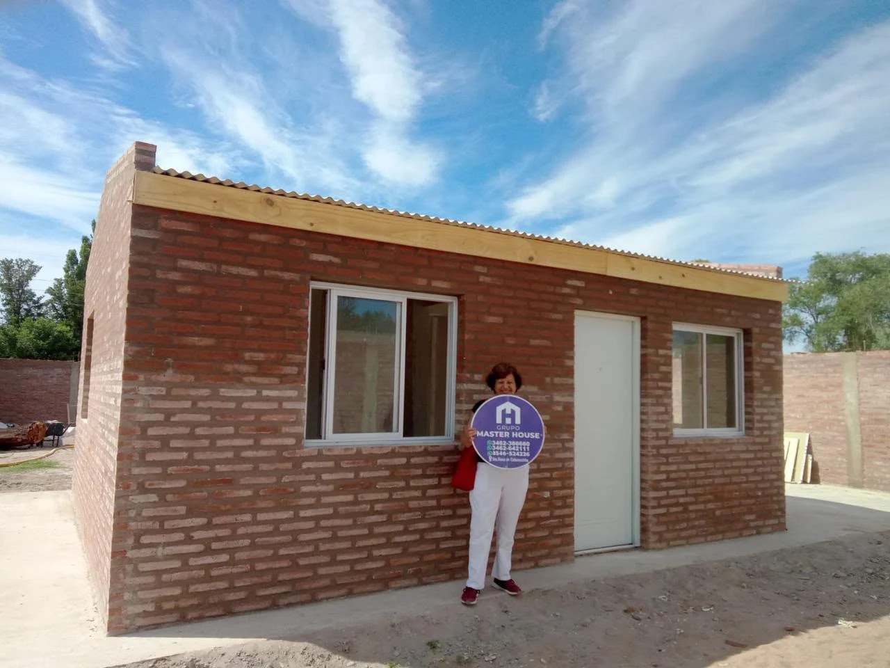 Clienta frente a su casa entregada por Grupo Master House