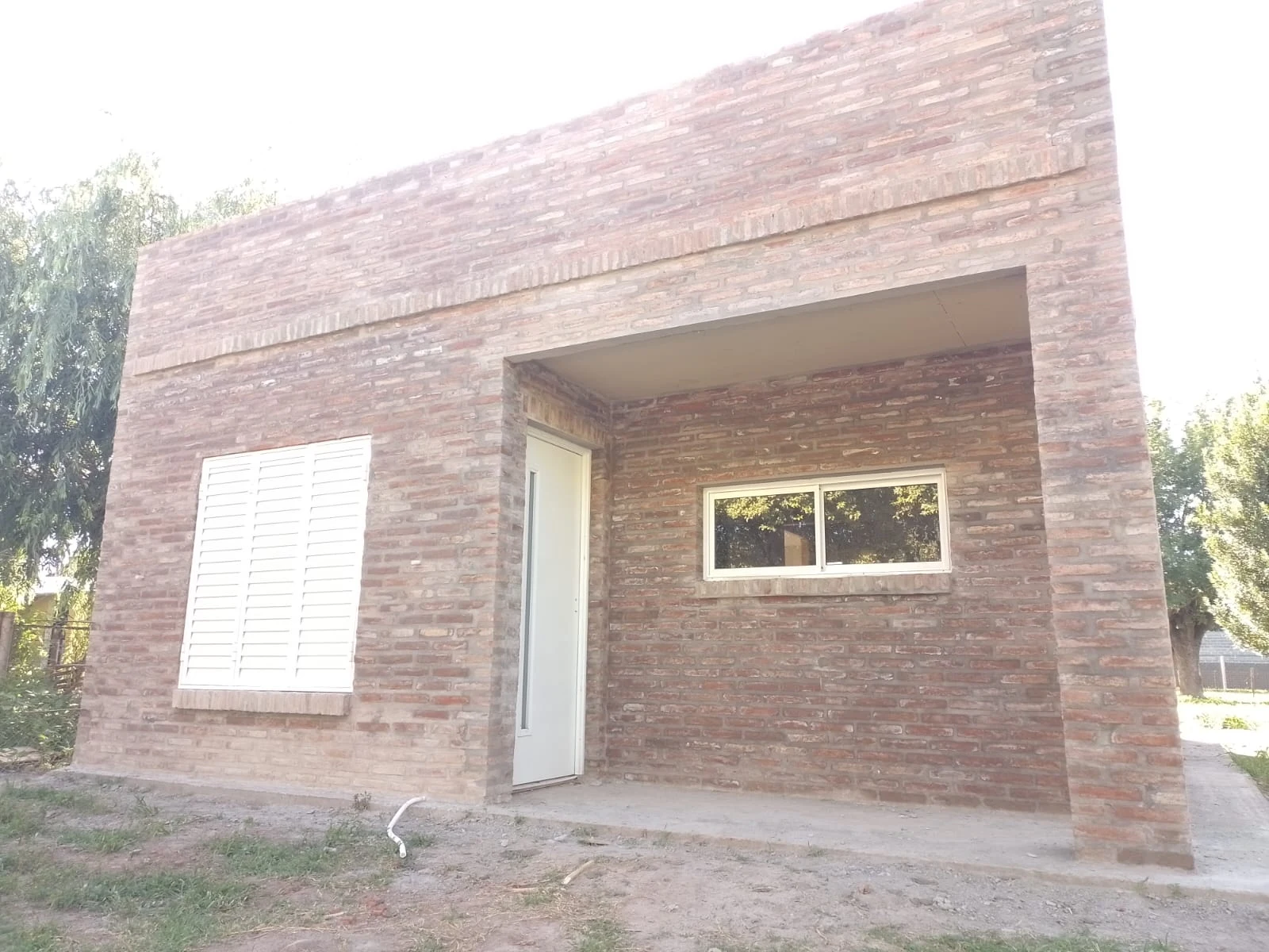 Vivienda real de Grupo Master House revestida en ladrillo, con aberturas blancas